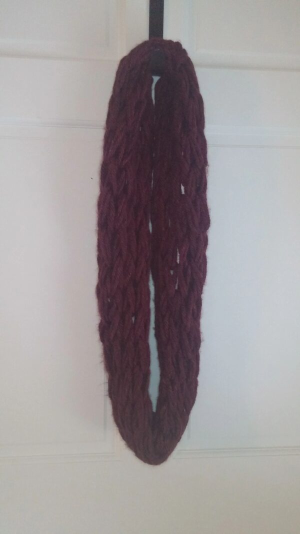 A long knitted scarf hanging on the wall.