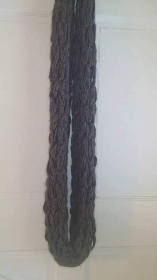 A long gray scarf is hanging on the wall.