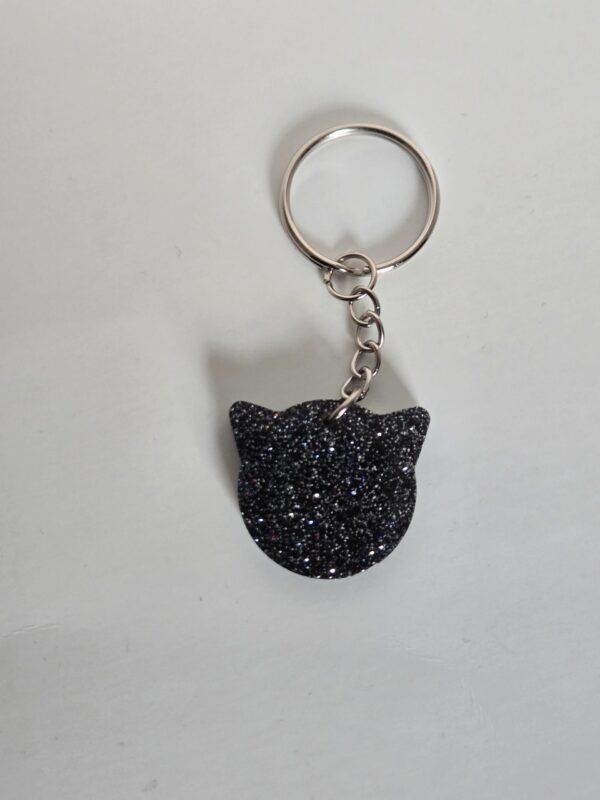 A black cat keychain with a black diamond pattern.