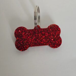 A red dog bone shaped key chain with a white background