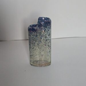 A glass candle holder with blue and white speckles.