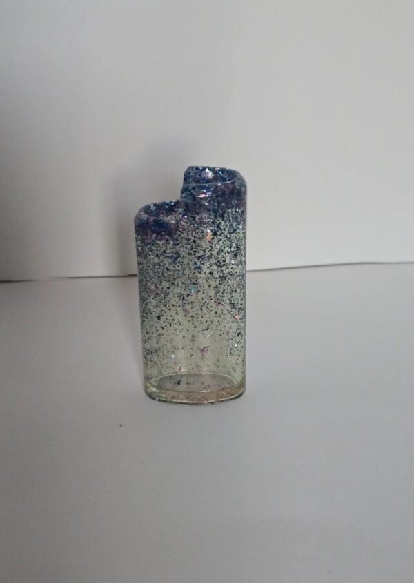 A glass candle holder with blue and white speckles.