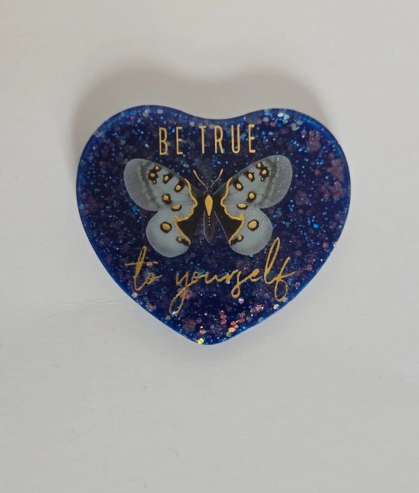 A heart shaped blue coaster with the words " be true to yourself ".