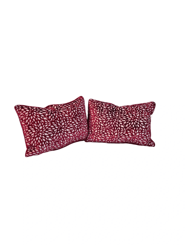 A pair of red pillows with white leopard print.