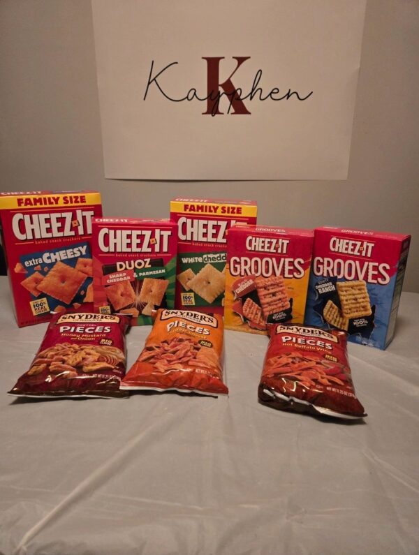 A table with several bags of cheez its and other snacks.