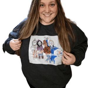 A woman holding onto a sweatshirt with drawings of people
