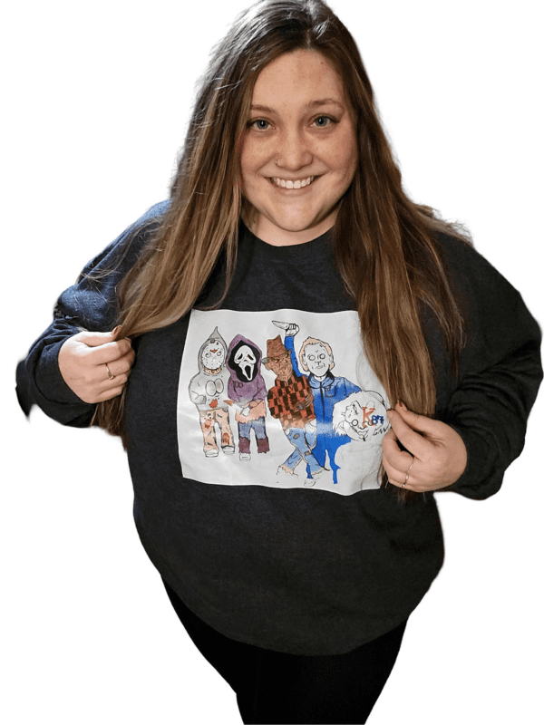 A woman holding onto a sweatshirt with drawings of people
