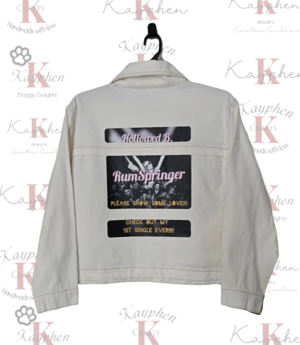 1000010175 A white jacket with a black and white design on the back.