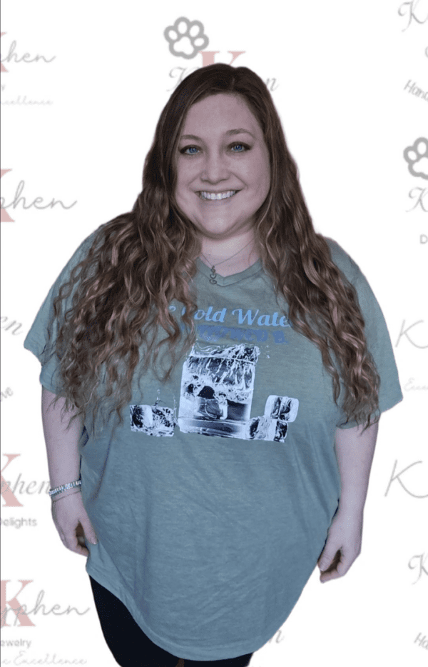 A woman standing in front of a wall with a picture on it.