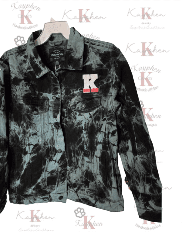 A black tie dye jacket with the letter k on it.