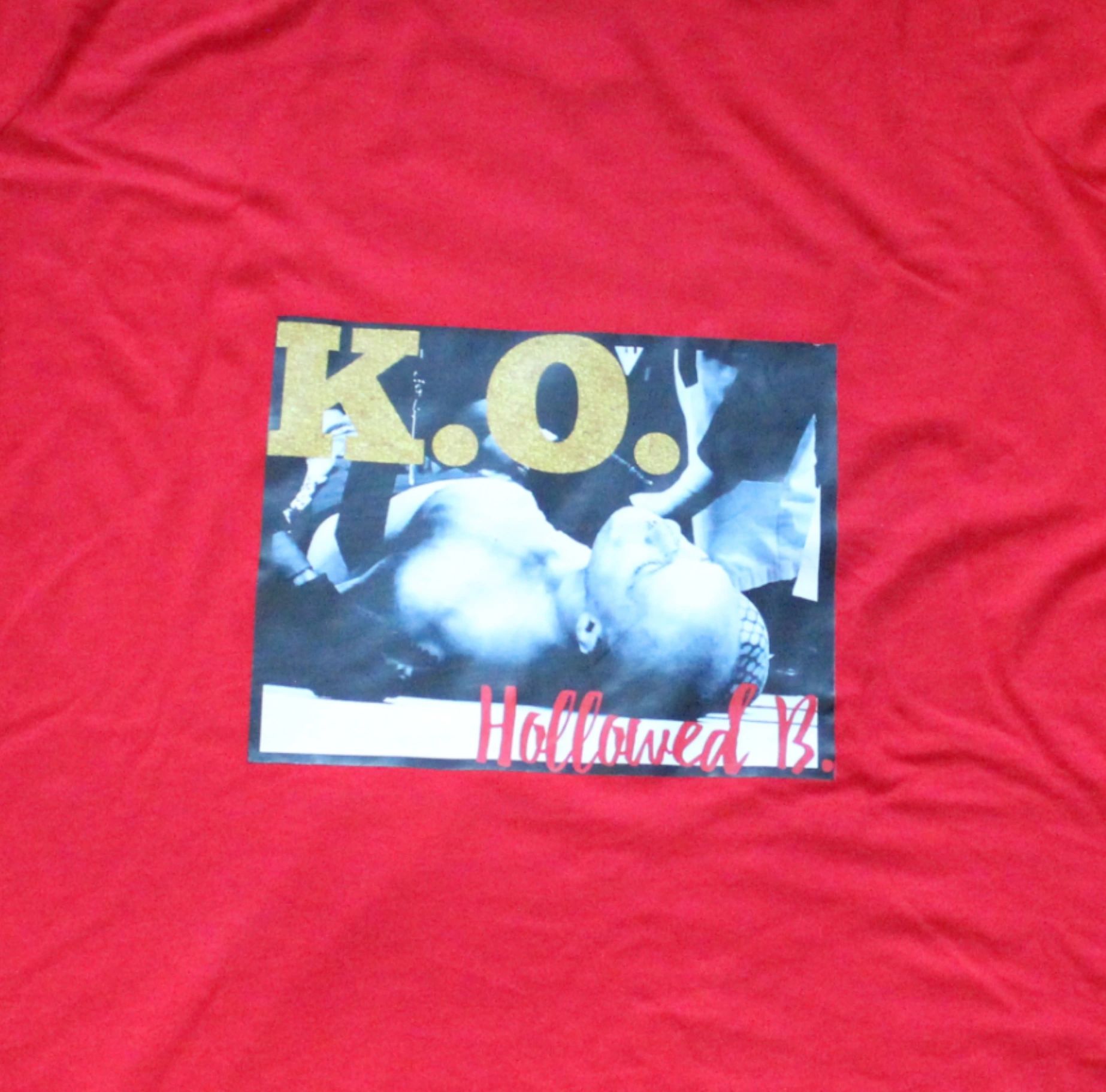 1000011058 A red shirt with a picture of two birds.