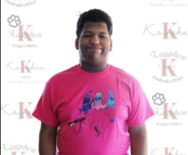 A man in a pink shirt standing next to a wall.