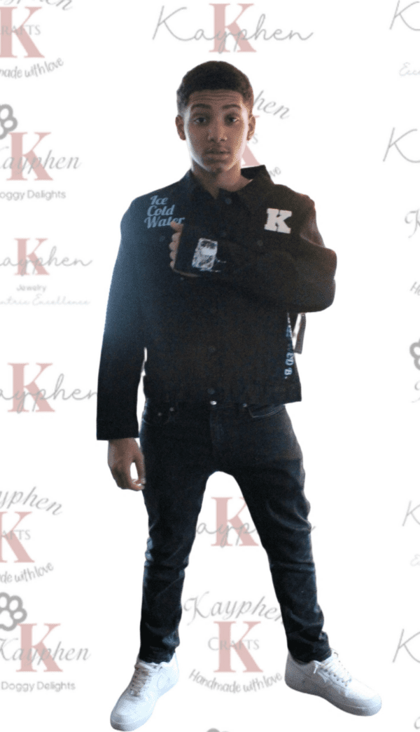 A man in black jacket and jeans standing on the red carpet.