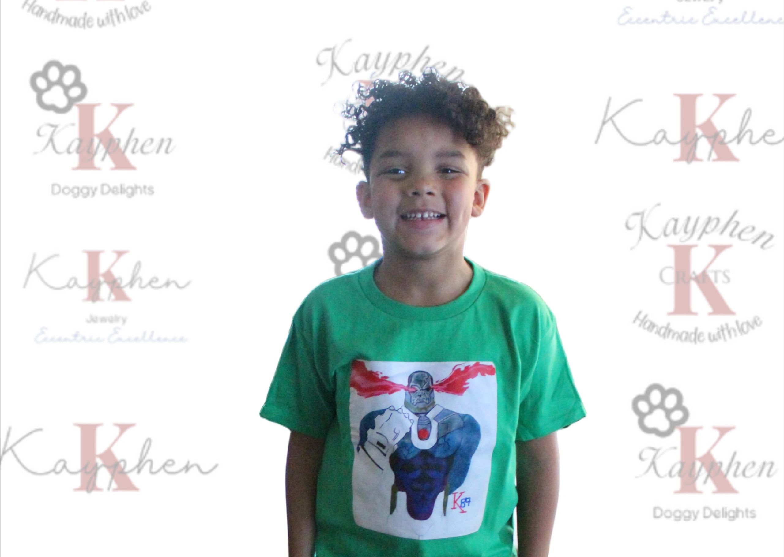 A young boy wearing a green shirt with an elephant on it.