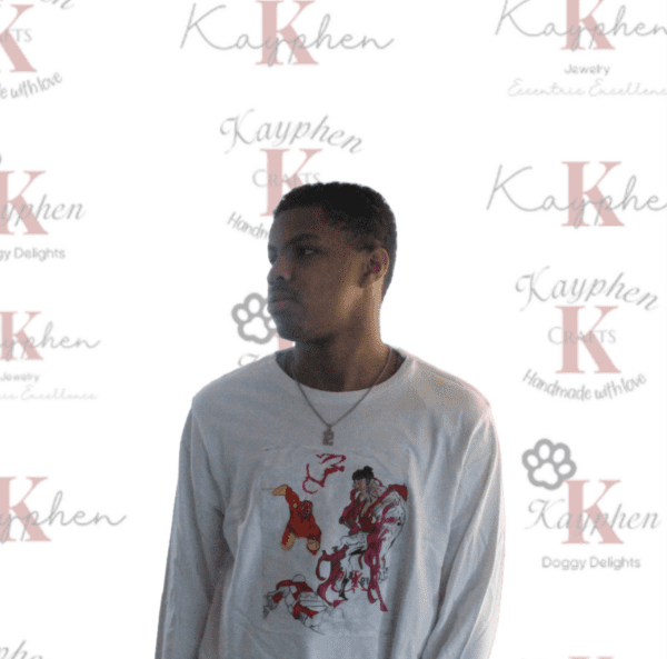A man standing in front of a wall with the words " kasheh k.