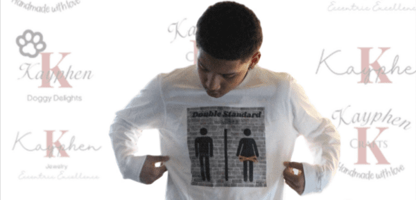 A man is pointing to his shirt with the picture of two men on it.