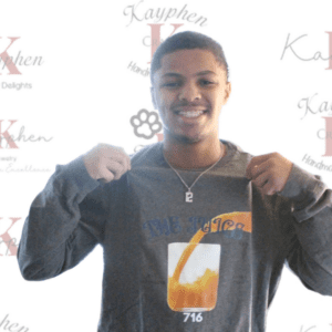 A young man holding onto the back of his shirt.