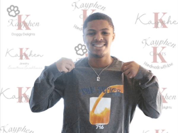 A young man holding onto the back of his shirt.
