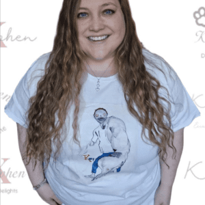 A woman standing in front of a wall with a t-shirt.
