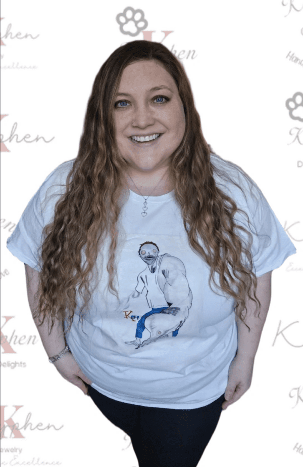 A woman standing in front of a wall with a t-shirt.