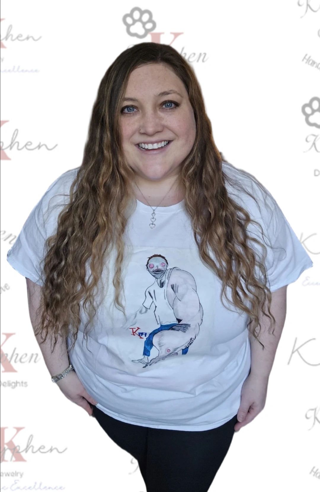 A woman standing in front of a wall with a t-shirt.