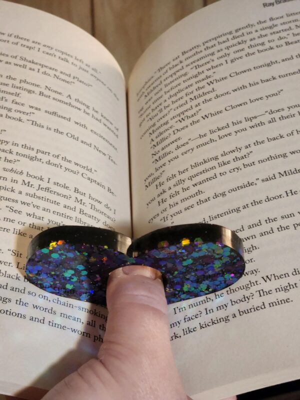 A person is holding onto the book page