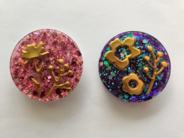 Two round shaped buttons with different designs on them.