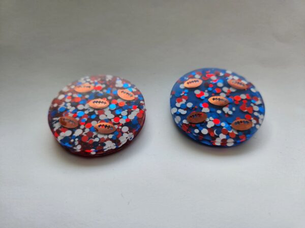 Two buttons with a pattern of red, white and blue flowers.