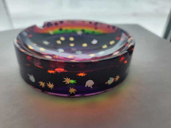 A colorful ashtray with some stars and planets on it