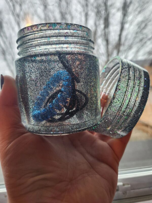 A person holding a jar with something inside of it.