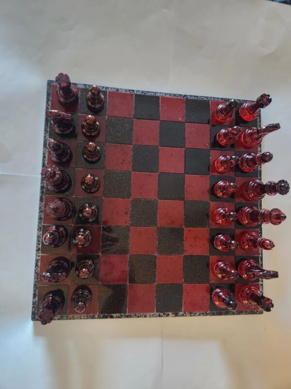 A red and black chess board with pieces on it