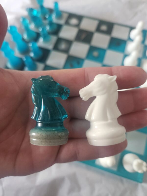 A person holding two chess pieces in their hand.