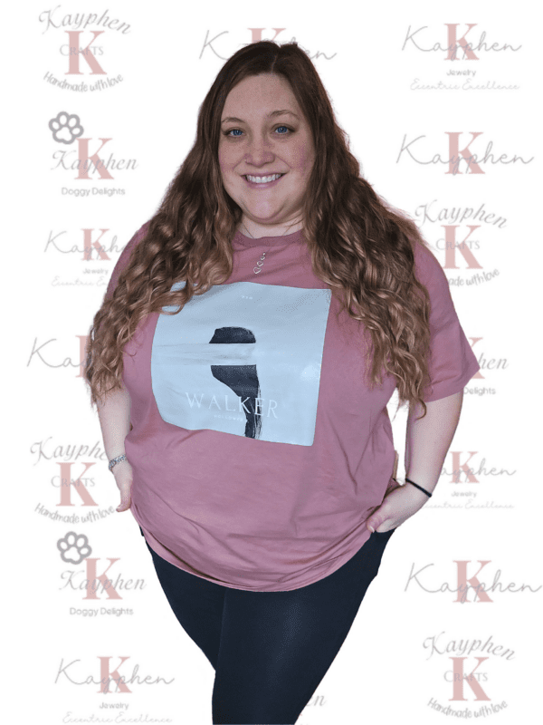 A woman standing in front of a wall with her hands on hips.