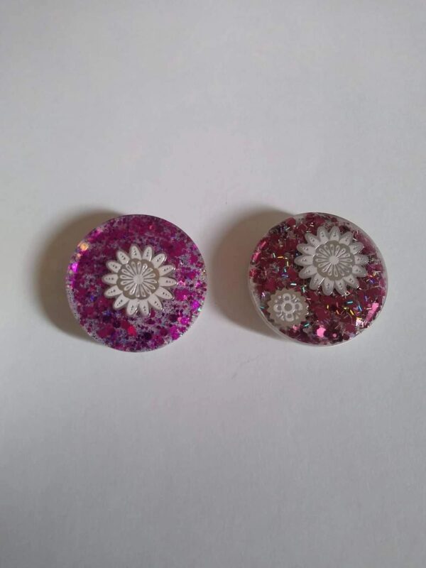 Two buttons with a flower design on them.