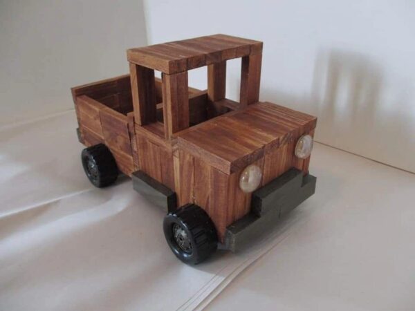 A wooden toy truck is sitting on the floor.