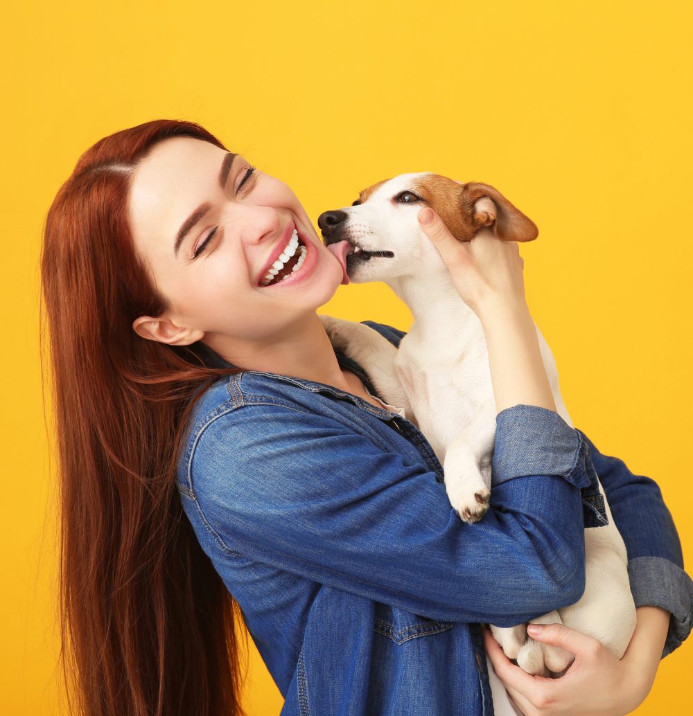 GettyImages-1318832543 (1) A woman holding a dog and kissing it.