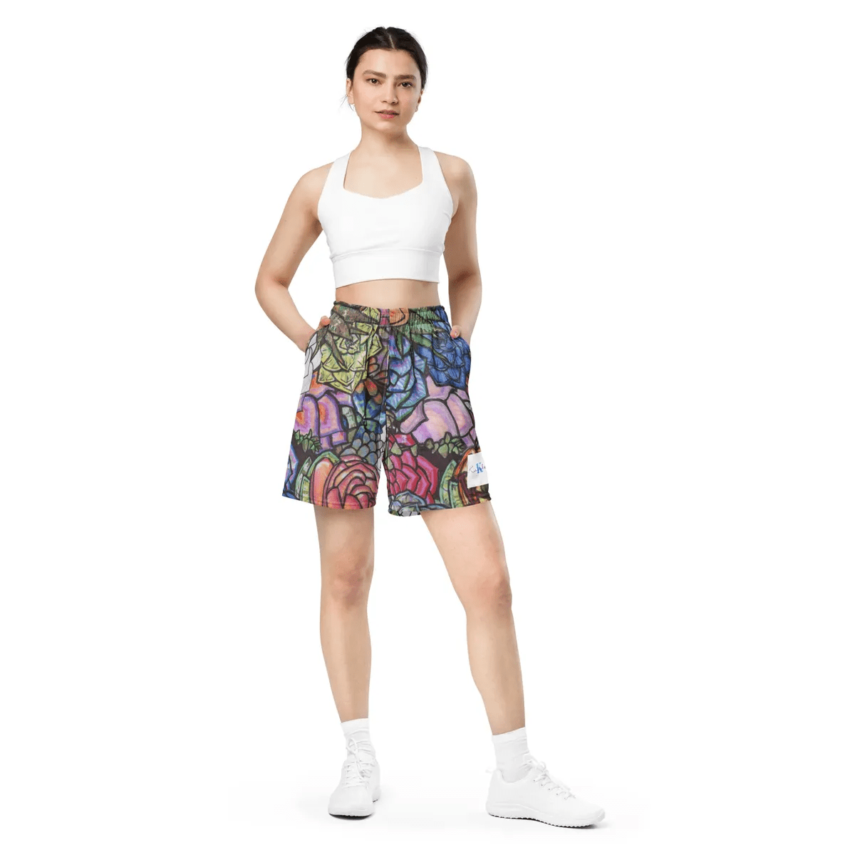 A woman wearing white top and shorts standing up.