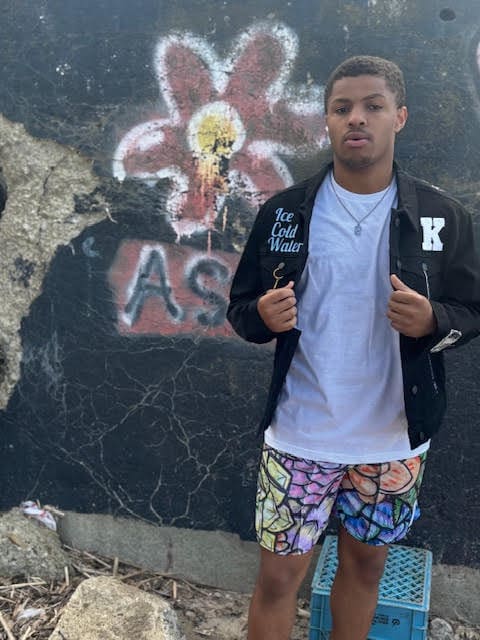 Person posing in front of graffiti wall.