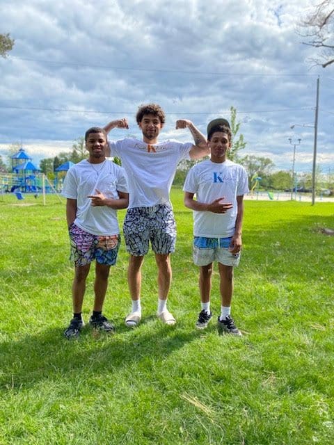 Three friends posing in a park.