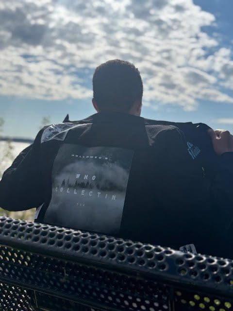 Person sitting on bench under cloudy sky.