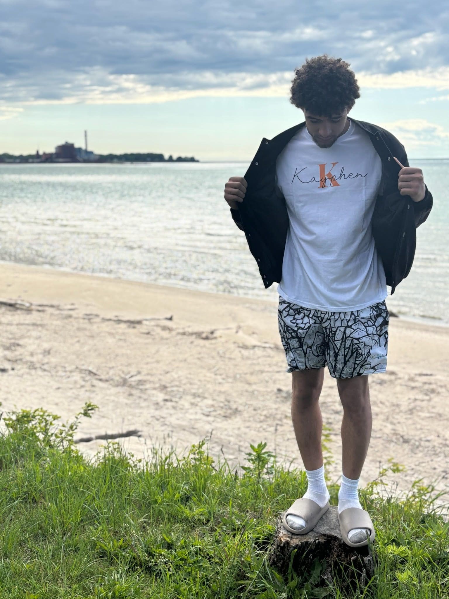 Person standing on stump by the beach.