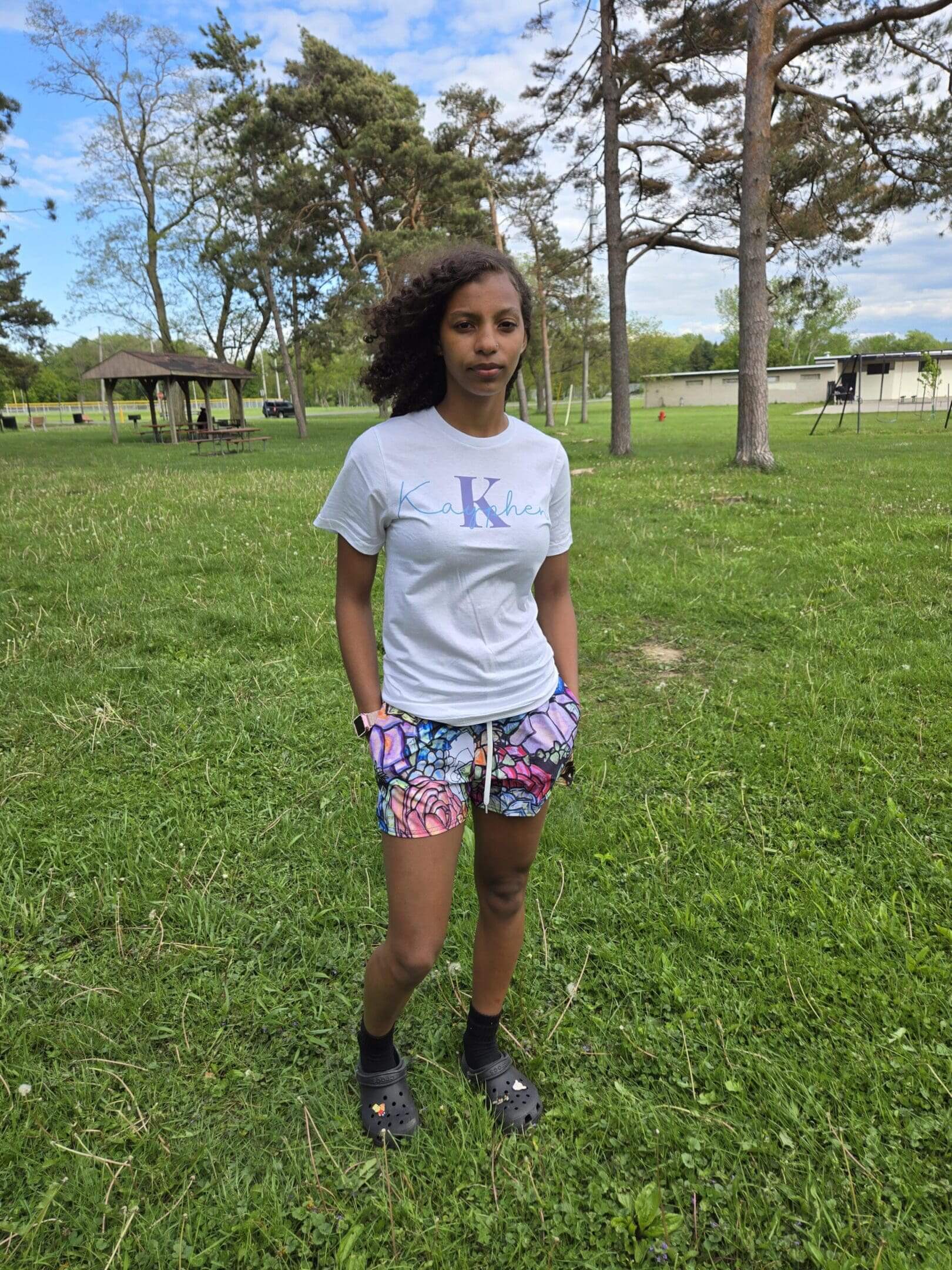 Person standing on grass in a park.